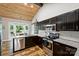 Kitchen with stainless appliances, granite counters, wood ceiling, and a sliding barn door at 616 Trailing Rock Dr, Charlotte, NC 28214
