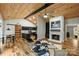 Open-concept living area with hardwood floors, wood ceilings, and a stone fireplace at 616 Trailing Rock Dr, Charlotte, NC 28214