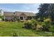 Well-manicured backyard with landscaped garden beds and a patio area at 6454 Sain Milling Rd, Vale, NC 28168
