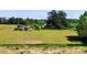 Picturesque landscape featuring a large green field, mature trees and outbuildings at 6454 Sain Milling Rd, Vale, NC 28168