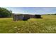 Rustic shed on a grassy field, adding to the property's rural charm at 6454 Sain Milling Rd, Vale, NC 28168