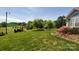 Lush green yard with mature trees and vibrant flowering shrubs at 6454 Sain Milling Rd, Vale, NC 28168