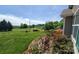 Scenic view of the expansive yard with lush greenery, flowering plants, and distant fields at 6454 Sain Milling Rd, Vale, NC 28168