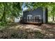 Blue home featuring a spacious wood deck surrounded by lush landscaping at 7212 Canyon Dr, Charlotte, NC 28262