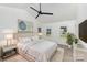 Stylishly staged bedroom with a ceiling fan, white walls, plush rug and bright windows at 7212 Canyon Dr, Charlotte, NC 28262