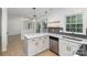 Bright kitchen features white cabinetry, quartz countertops, stainless steel appliances, and modern pendant lighting at 7212 Canyon Dr, Charlotte, NC 28262
