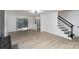 Spacious living area with wood floors, a fireplace, and staircase, leading to outdoor access via sliding doors at 7212 Canyon Dr, Charlotte, NC 28262