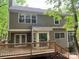 Back exterior view of the house featuring a spacious wooden deck surrounded by lush greenery at 7401 Kinsmore Ln, Charlotte, NC 28269