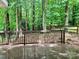 Deck with a railing surrounded by tall green trees at 7401 Kinsmore Ln, Charlotte, NC 28269