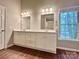 Bathroom featuring a double vanity with two mirrors and modern light fixtures at 7401 Kinsmore Ln, Charlotte, NC 28269
