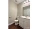 Compact half bathroom features a vanity, toilet, and mirror, great for guests at 7401 Kinsmore Ln, Charlotte, NC 28269