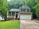 Charming two-story home with a white garage door, covered porch, and well-manicured lawn at 7401 Kinsmore Ln, Charlotte, NC 28269