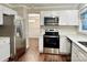 Modern kitchen featuring stainless steel appliances, white cabinets, and hardwood floors at 7401 Kinsmore Ln, Charlotte, NC 28269