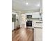 Well-appointed kitchen featuring stainless steel appliances, white cabinets, and hardwood floors at 7401 Kinsmore Ln, Charlotte, NC 28269