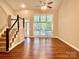 Bright living room with hardwood floors, a staircase, and large windows offering ample natural light at 7401 Kinsmore Ln, Charlotte, NC 28269