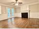 Cozy living room with fireplace, ceiling fan, wood floors and access to the yard through french doors at 7401 Kinsmore Ln, Charlotte, NC 28269