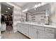 Stylish bathroom featuring double sinks with modern cabinetry, decorative wallpaper, and an open doorway to a walk-in closet at 8107 Houser St, Cornelius, NC 28031