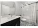 Bathroom features a shower over tub and modern vanity with black and white patterned floors at 8107 Houser St, Cornelius, NC 28031