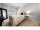 Neutral bedroom featuring a queen bed and large window with blinds at 8107 Houser St, Cornelius, NC 28031