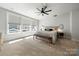 Bright bedroom with neutral tones, featuring a comfortable bed, a ceiling fan, and a window letting in natural light at 8107 Houser St, Cornelius, NC 28031