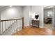 Bright hallway featuring a wooden railing, modern decor, and access to other rooms, creating a welcoming and stylish space at 8107 Houser St, Cornelius, NC 28031