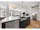 Open-concept kitchen with stainless steel appliances, island sink, and seamless flow to the dining and living areas at 8107 Houser St, Cornelius, NC 28031