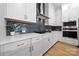 Elegant kitchen with white cabinetry, blue mosaic backsplash, and modern stainless steel appliances at 8107 Houser St, Cornelius, NC 28031