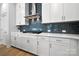 Stylish kitchen showcasing white cabinets, a blue mosaic backsplash, and stainless steel range hood at 8107 Houser St, Cornelius, NC 28031