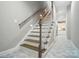 Staircase with dark wood treads, white risers, and a view into the well-lit kitchen at 8473 Bing Cherry Dr, Denver, NC 28037