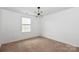 A bedroom with neutral walls featuring a modern light fixture and carpeted floor at 10417 Ebbets Rd, Charlotte, NC 28273