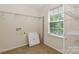 Spacious laundry room with tile floor, built-in shelves, window, and washer/dryer hookups at 10417 Ebbets Rd, Charlotte, NC 28273