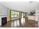 Bright living room features fireplace, hardwood floors, and a wall of sunny windows at 10417 Ebbets Rd, Charlotte, NC 28273
