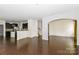 Open-concept living space showcasing hardwood floors and an arched entry to an adjacent room at 10417 Ebbets Rd, Charlotte, NC 28273