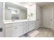 Bright bathroom featuring double vanity with white cabinets and gray tile floors and shower at 115 Haddonsfield Dr, Mooresville, NC 28115