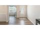 Bright entryway featuring decorative glass door, wood-look flooring, and view into adjacent sunroom at 115 Haddonsfield Dr, Mooresville, NC 28115
