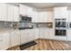 Modern kitchen featuring white cabinets, stainless steel appliances, and a stylish backsplash at 115 Haddonsfield Dr, Mooresville, NC 28115