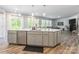 Open kitchen with island, stainless steel appliances, and seamless flow to the living area at 115 Haddonsfield Dr, Mooresville, NC 28115