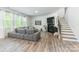 Spacious living room features stylish grey couch, cozy fireplace, and adjacent staircase at 115 Haddonsfield Dr, Mooresville, NC 28115