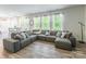 Spacious living room featuring stylish gray couch, lots of windows, and wood-look flooring at 115 Haddonsfield Dr, Mooresville, NC 28115