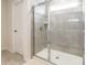 Updated bathroom shower with glass doors, gray tile and built-in shelving at 115 Haddonsfield Dr, Mooresville, NC 28115