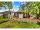 Backyard of a red brick house featuring a brick patio, greenhouse, and various foliage at 119 Wiley Ave, Salisbury, NC 28144