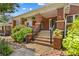 Inviting brick porch with stone accents, wrought iron railings, and lush landscaping creates a welcoming entrance at 119 Wiley Ave, Salisbury, NC 28144