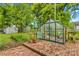 Backyard greenhouse with brick flooring and assorted greenery at 119 Wiley Ave, Salisbury, NC 28144