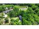 An aerial view shows a home next to a lake surrounded by lush trees in a beautiful lakeside setting at 136 Dogwood Ln, Shelby, NC 28150