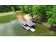 A dock featuring a covered area with attached slips sits on calm waters with a nearby beach area at 136 Dogwood Ln, Shelby, NC 28150