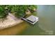 A boat dock featuring a covered area with attached slips sits on calm waters with a lakeside path nearby at 136 Dogwood Ln, Shelby, NC 28150