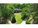 This aerial view showcases a brick home with a pristine lawn and driveway, complemented by mature trees at 136 Dogwood Ln, Shelby, NC 28150