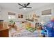Bright, carpeted bedroom with a ceiling fan, natural light, and ample space for playing at 1628 Starbrook Dr, Charlotte, NC 28210