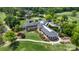 Aerial view of the clubhouse and surrounding landscape featuring a golf course and lush trees at 18730 Floyd Ct, Davidson, NC 28036