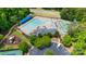 Aerial view of community pool, playground, tennis court and parking lot surrounded by lush green trees at 18730 Floyd Ct, Davidson, NC 28036